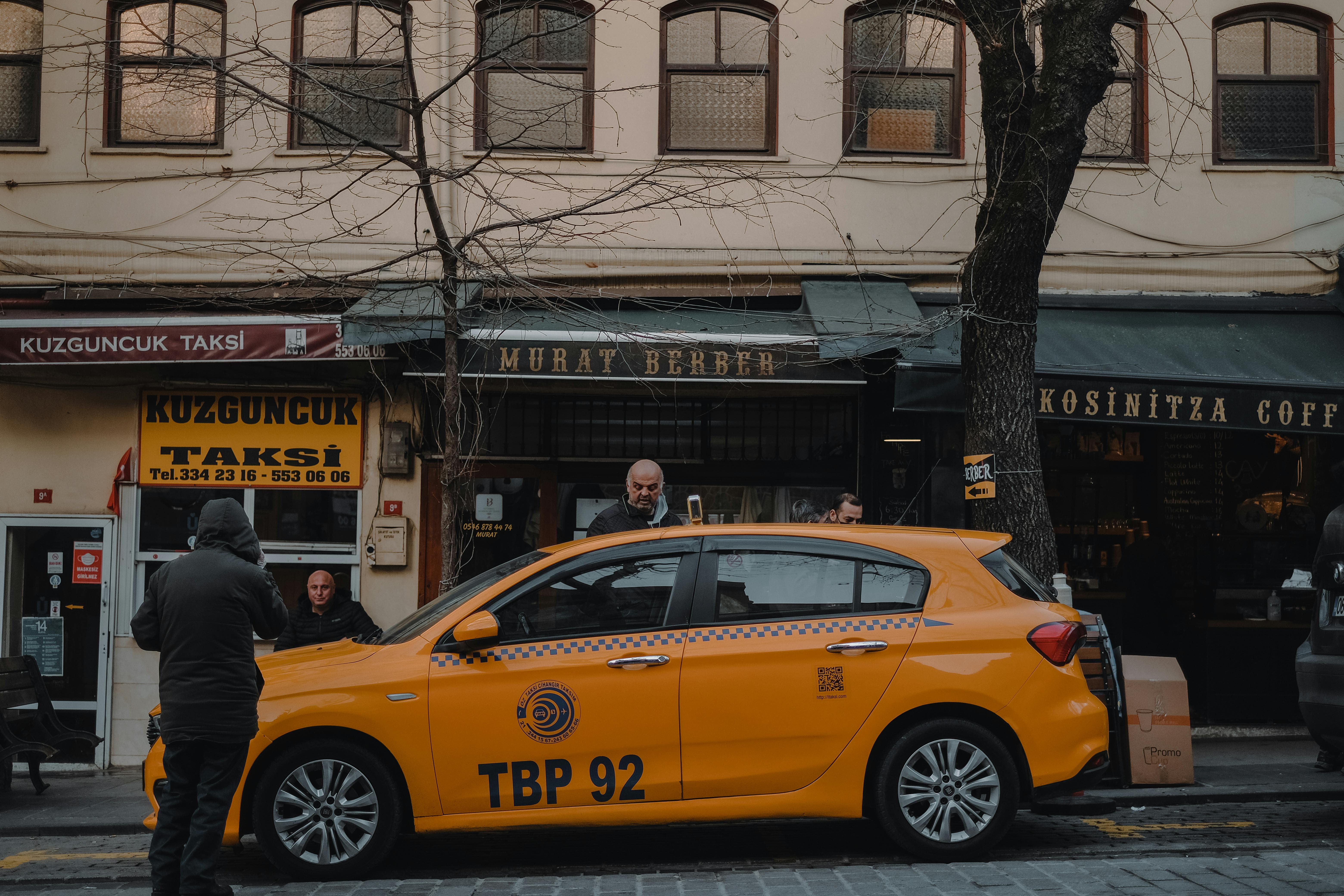 Free Street view of a yellow taxi parked in front of stores in Istanbul's Kuzguncuk neighborhood. Stock Photo