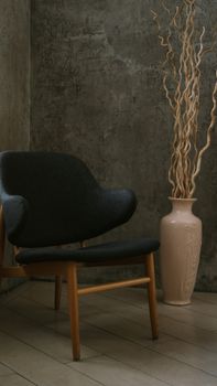 A mid-century modern chair beside a decorative vase in a minimalistic indoor setting.. century, modern, chair
