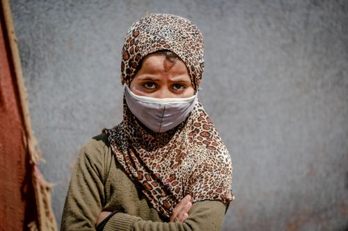 Free A young girl in Idlib, Syria, wearing a face mask and leopard print hijab, outdoors. Stock Photo