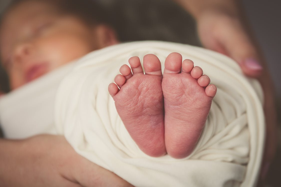 A Baby Wrapped in a Blanket with Exposed Feet