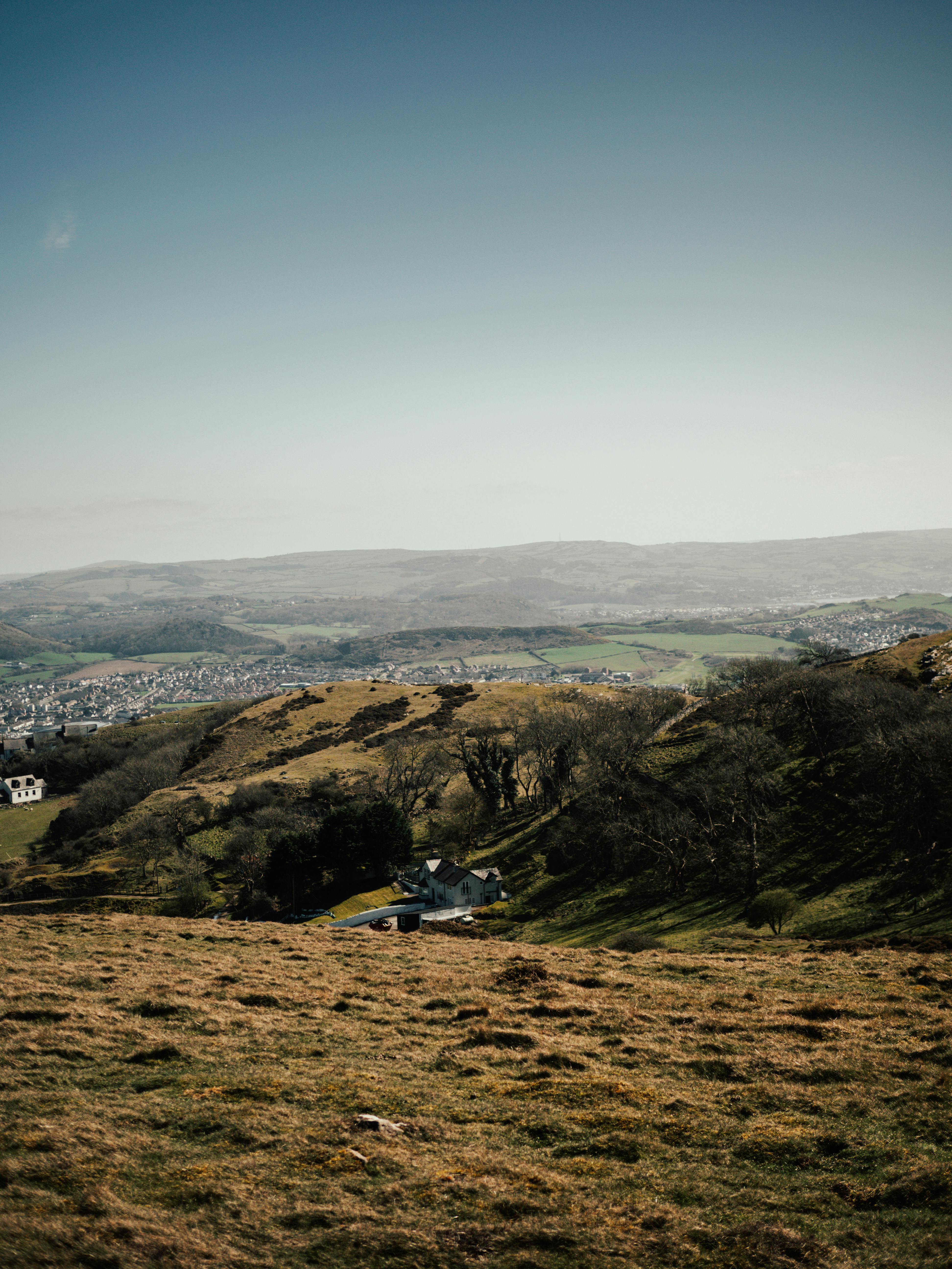 Picturesque landscape of rolling hills in Wales with distant town view.