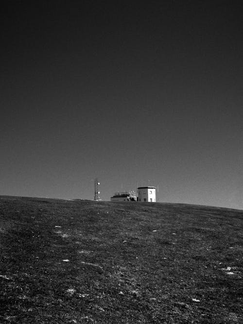 Grayscale Photo of a Building on Mountain