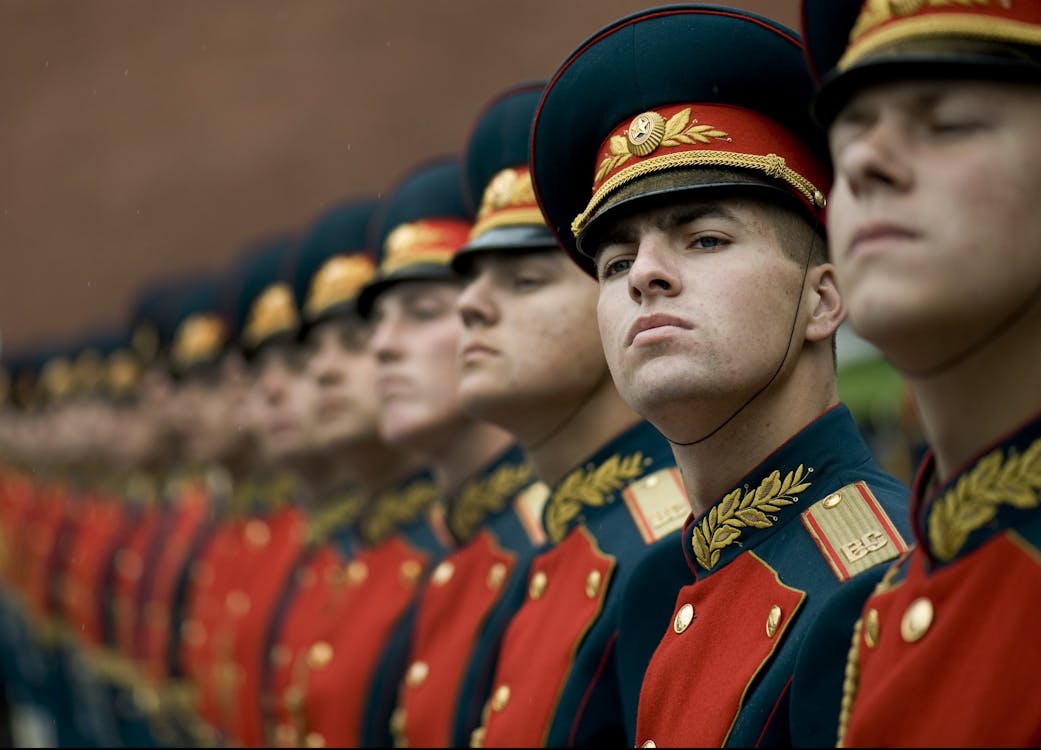 Free Men in Black and Red Cade Hats and Military Uniform Stock Photo