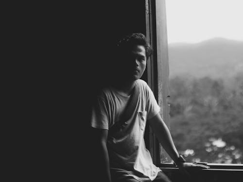 Portrait of a Man Standing by a Window