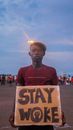 Man Wearing a Hat Holding a Placard with a Text Stay Woke