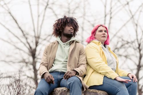 Free Interracial friends with unique hair colors sitting on a rock outdoors. Stock Photo