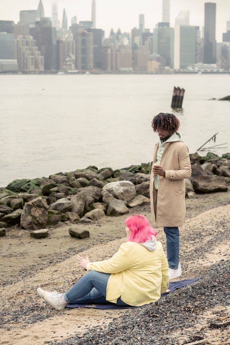 Diverse Couple Resting On Embankment