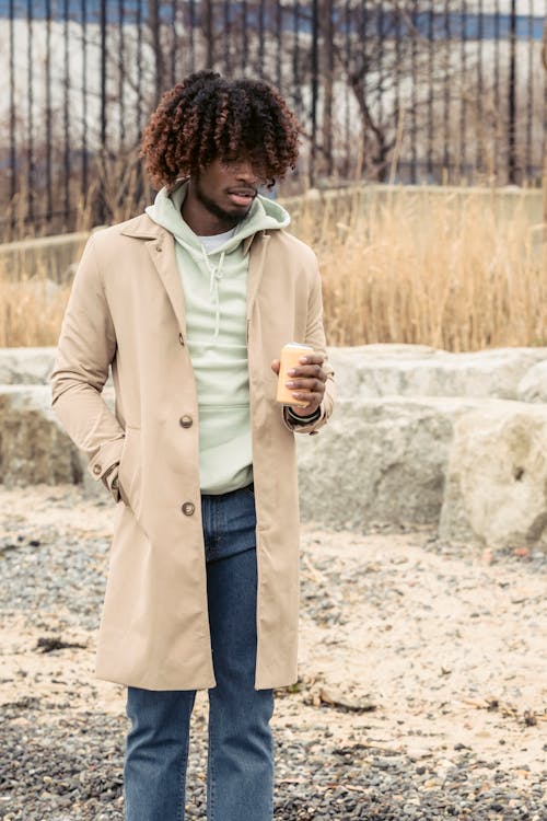 Stylish black man with can of soda on street