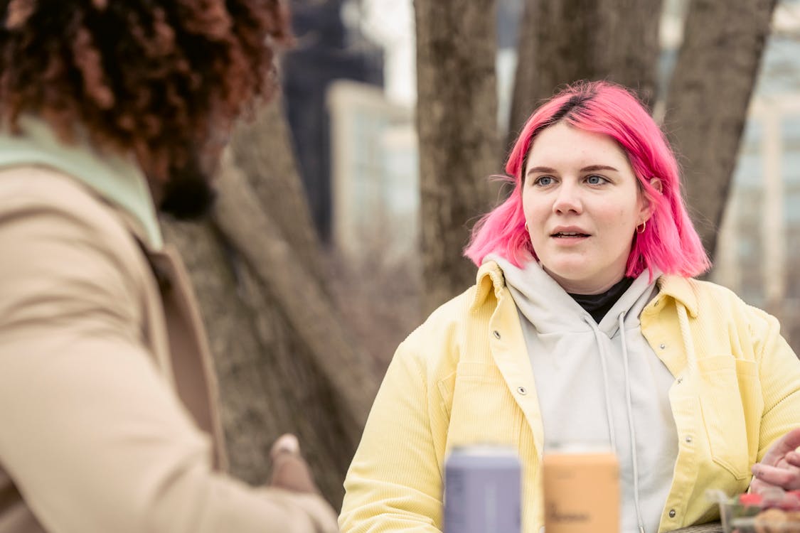 Woman speaking with faceless black man in park