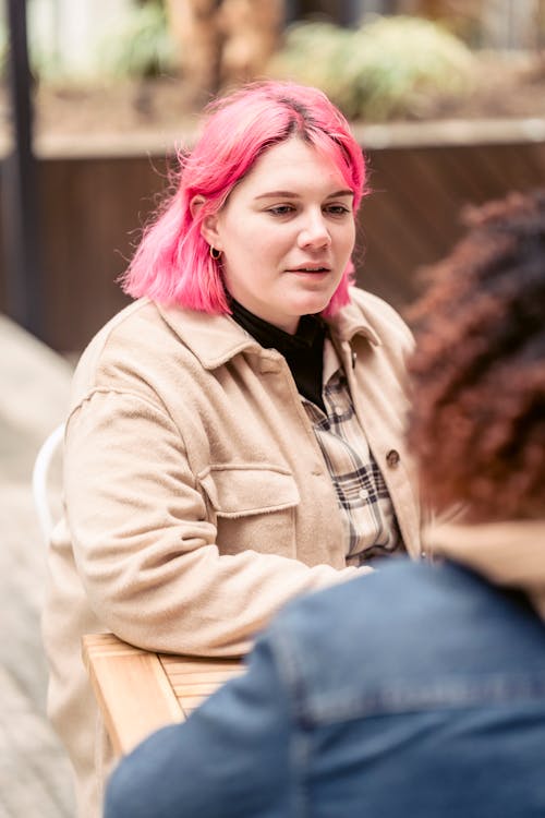 Free Young woman speaking with friend in cafe Stock Photo
