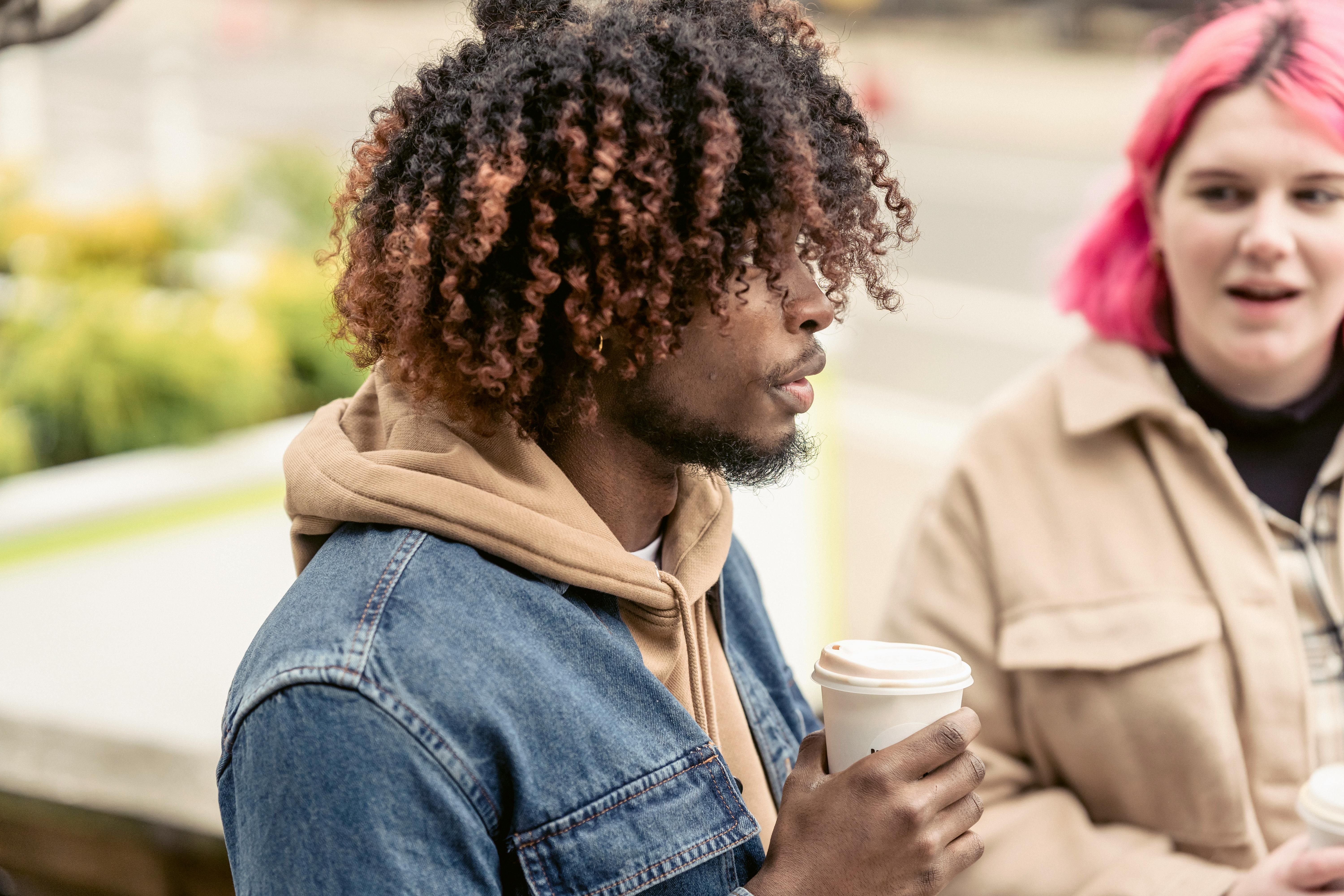 stylish young multiethnic friends having coffee break in park