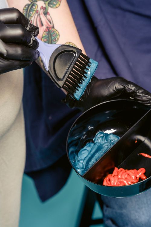 Free From above anonymous woman in latex gloves mixing bright paint in plastic bowl while working in hairdressing salon Stock Photo