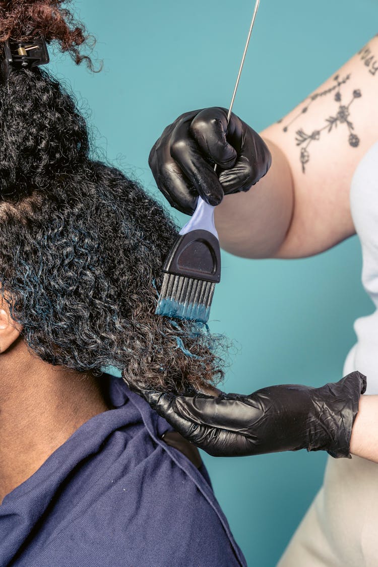 Woman Applying Dye On Hair Of Black Man