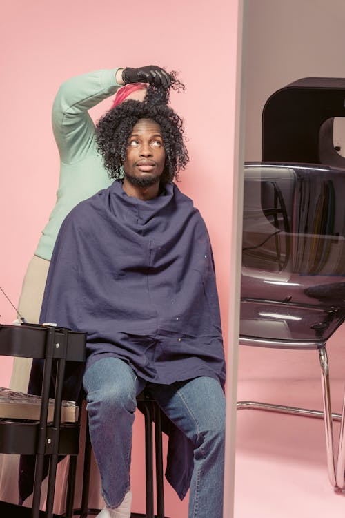 Free Woman doing hairstyle to black customer Stock Photo