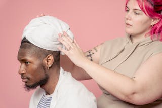 Hairdresser dying hair of black male customer