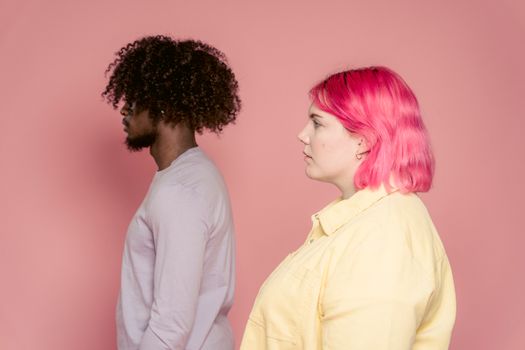 Multiracial friends in casual clothes on pastel background