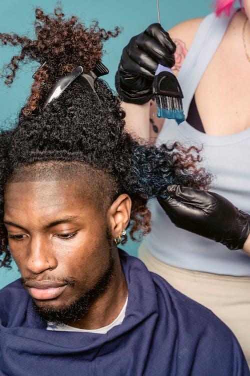 Black man and master dying hair in salon