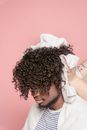 Anonymous stylist drying hair of black client