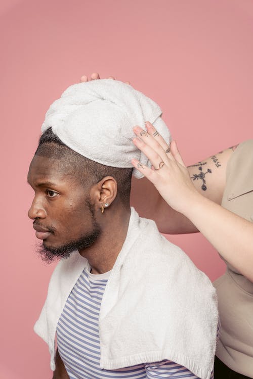 Black man with towel on head in salon