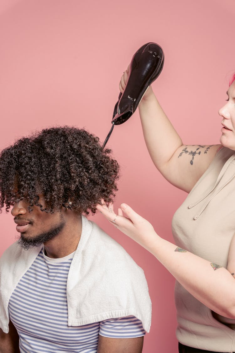 Hairstylist Drying Hair Of Black Client