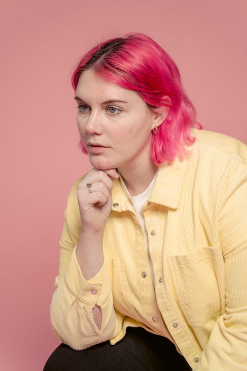 Thoughtful woman with bright hair in studio