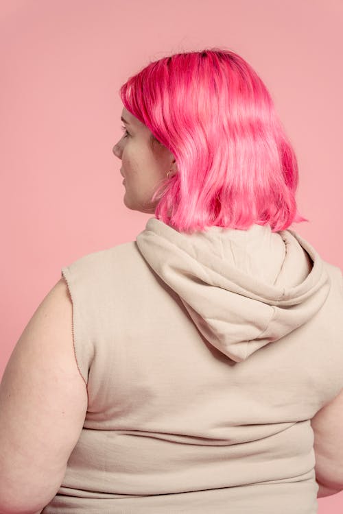 粉红色头发的年轻女子的后视图