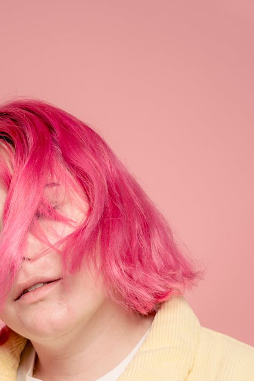 Gentle female model with pink hair and closed eyes