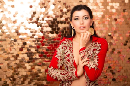 Woman with makeup and earrings near wall