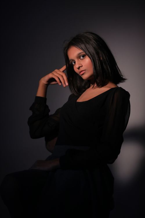 Free Sophisticated studio portrait of a woman in a thoughtful pose, highlighting elegance and style. Stock Photo