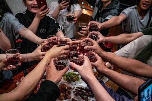 A Group of People Toasting Alcoholic Drinks in a Glass