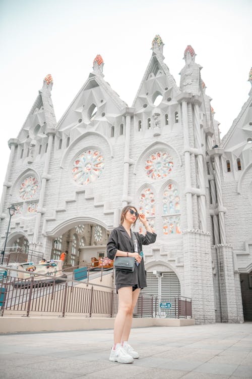 A Woman in Black Long Sleeve Shirt Standing Near Gray Building