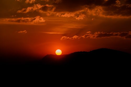 Free A breathtaking sunset with a vibrant orange sky and mountain silhouette, capturing nature's beauty. Stock Photo