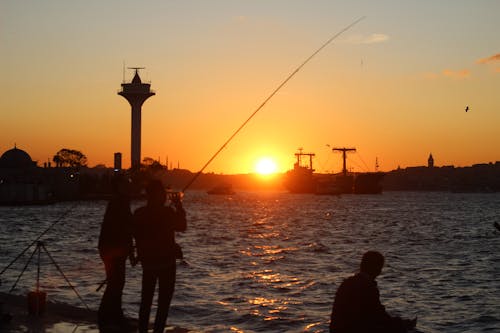 Free Silhouette of People Fishing on a River during Sunset Stock Photo