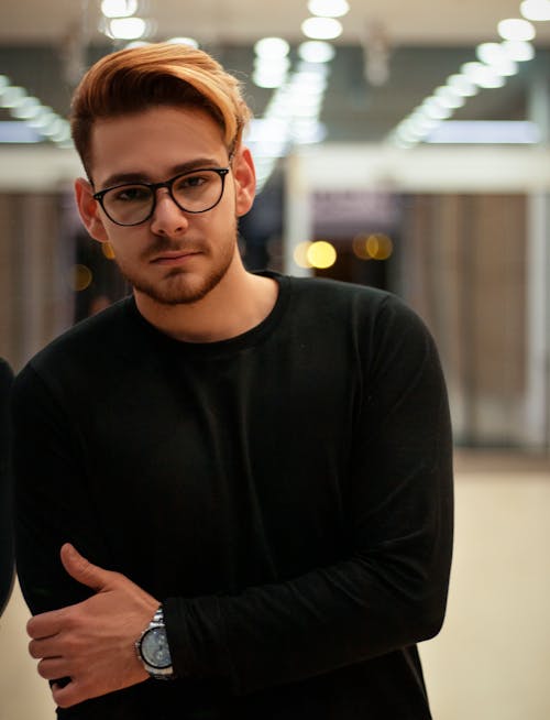 Portrait of a Man in a Black Long Sleeve Shirt Posing with His Hand on His Arm