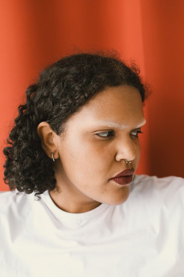 Nostril piercing against red