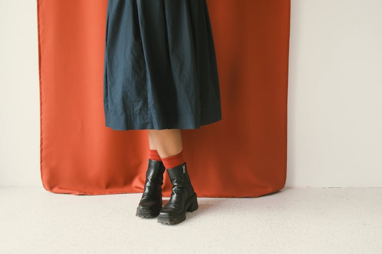 Woman In A Black Midi Skirt, Black Boots And Red Socks 