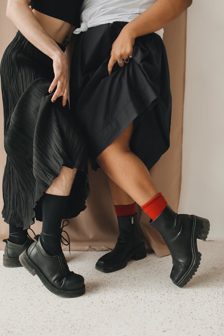 Persons Wearing Black Skirts And Black Leather Shoes Standing Close Together