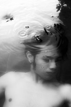 Black and white artistic portrait of a man underwater in a Manila swimming pool.
