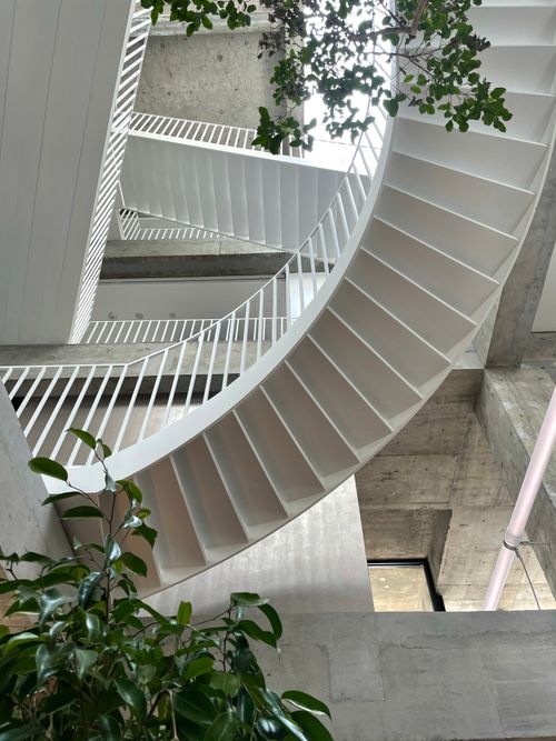 Free Elegant spiral staircase in a modern building with a minimalist aesthetic. Stock Photo