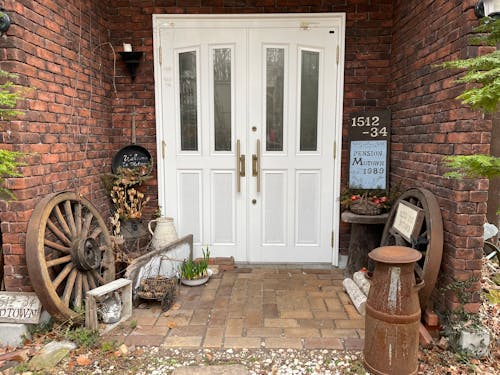 White Wooden Door Near Brown Brick Walls