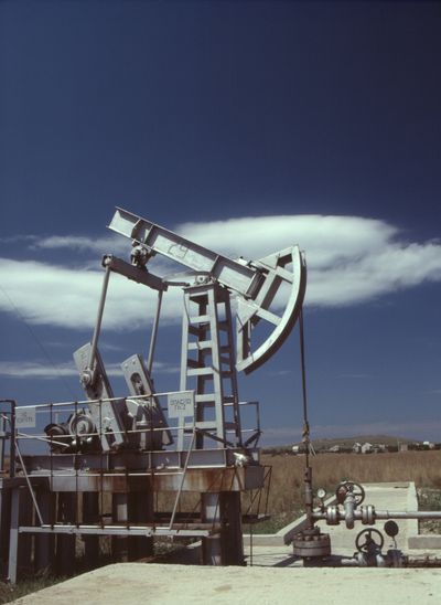 Oil pump jack under cloud, photo by Yuri Shkoda on Pexels