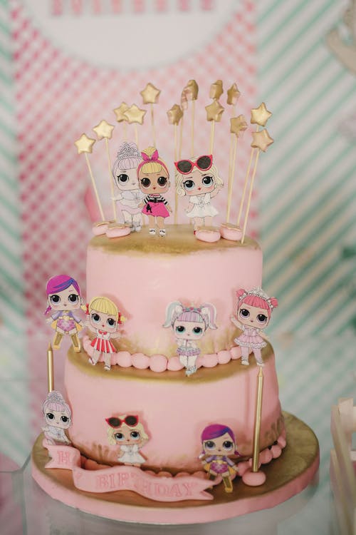 Pink birthday cake with small edible toys