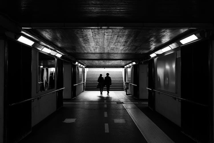 Couple Walking To Staircase In Underground Station