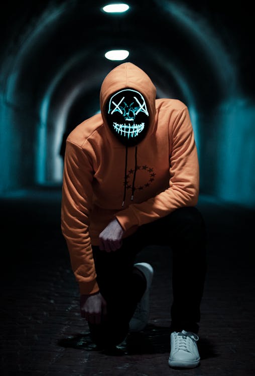 A Person in Brown Hoodie Wearing a Glow in the Dark Mask