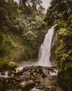 People Sitting on Rock Near Waterfalls