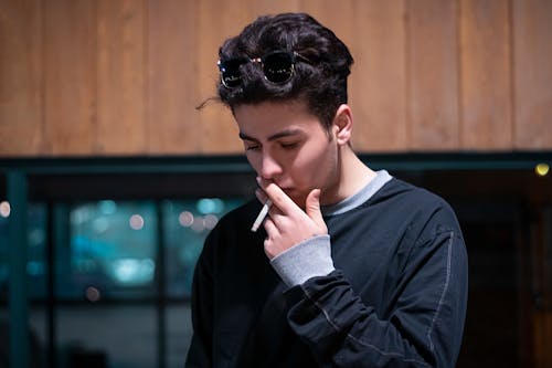 Free Handsome Man in Black long Sleeve Shirt Smoking a Cigarette Stock Photo