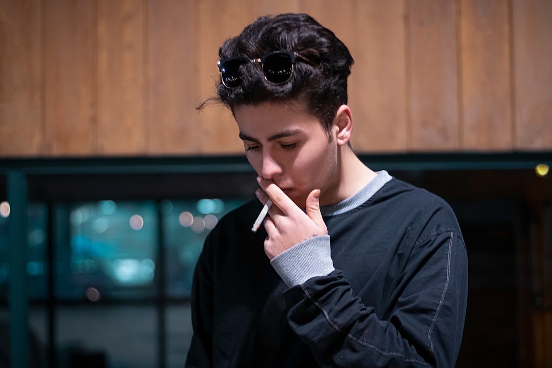 Handsome Man in Black long Sleeve Shirt Smoking a Cigarette