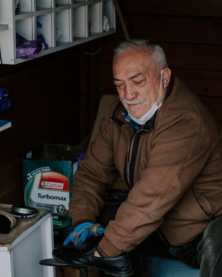 Man In Brown Jacket Shining A Shoe