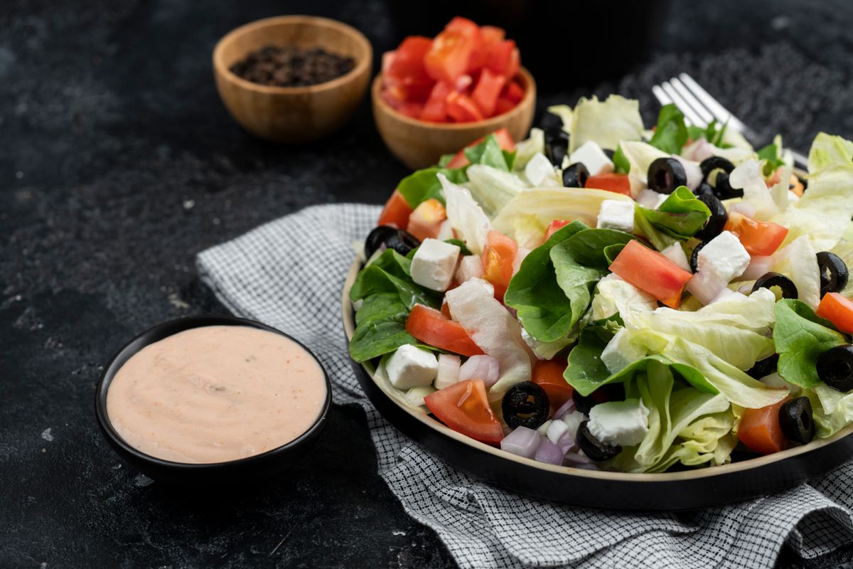 Fresh garden salad with lettuce, tomato, feta and olives in a bowl