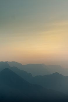Sunrise over misty mountains creating a serene and peaceful atmosphere in nature.